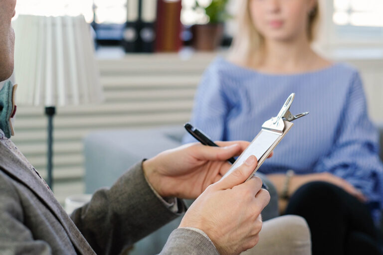 Doctor listening to his young patient while looking at a chart